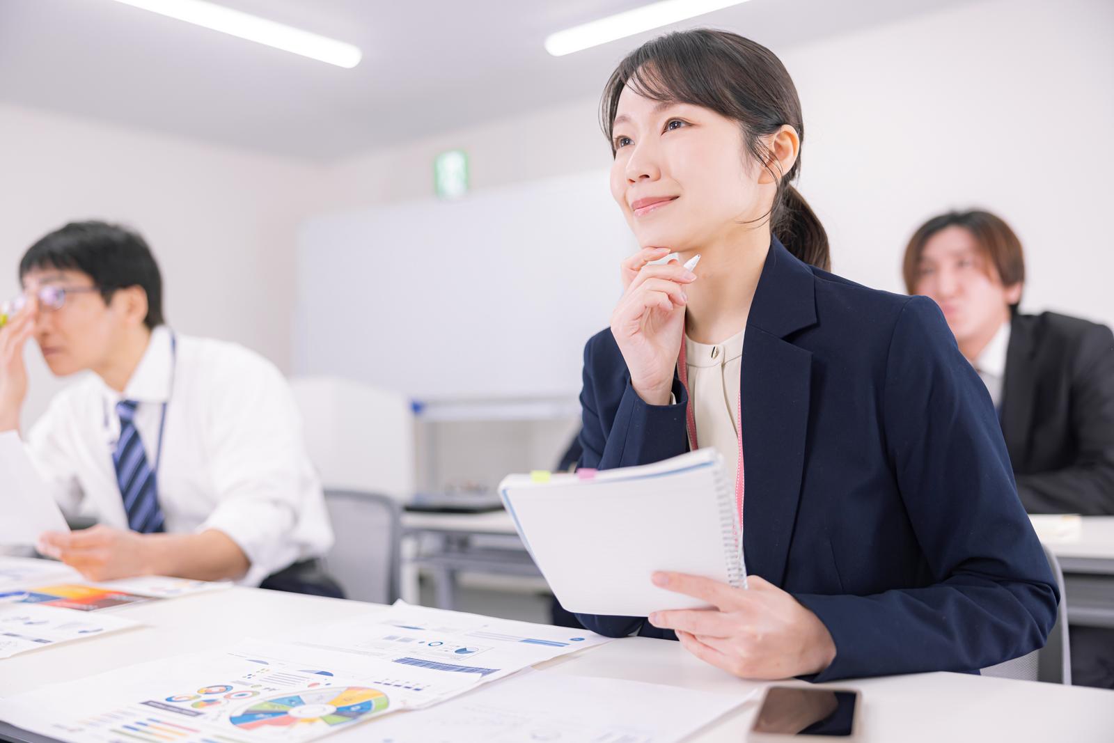 セミナーでノートを取りながら学ぶ参加者