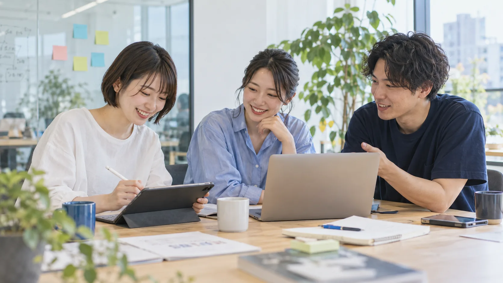 PCとタブレットを囲み、アイデアを形にしていく若い3人のチーム