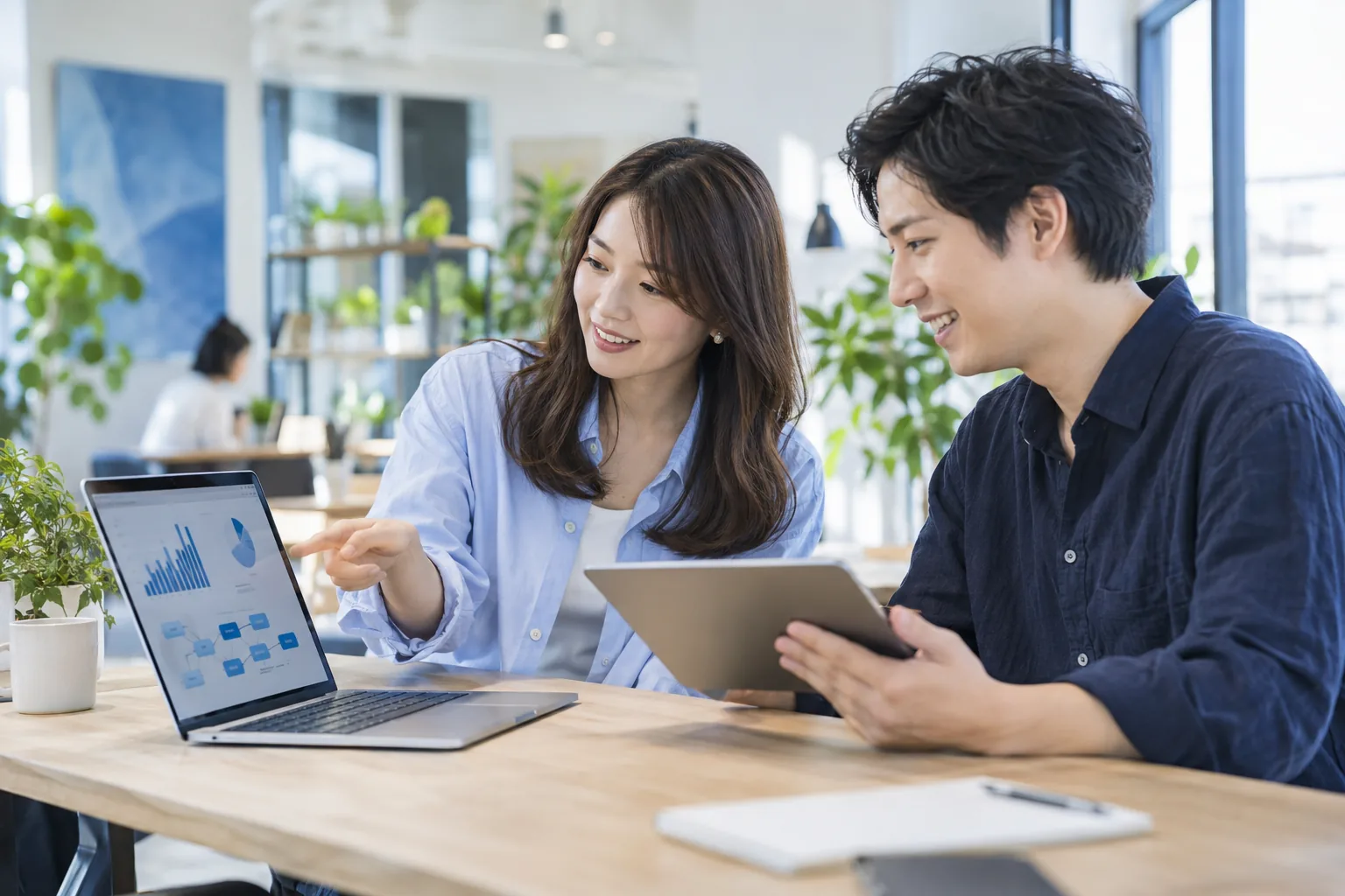 PCの分析画面とタブレットを見ながら施策を考える若いマーケティングチーム