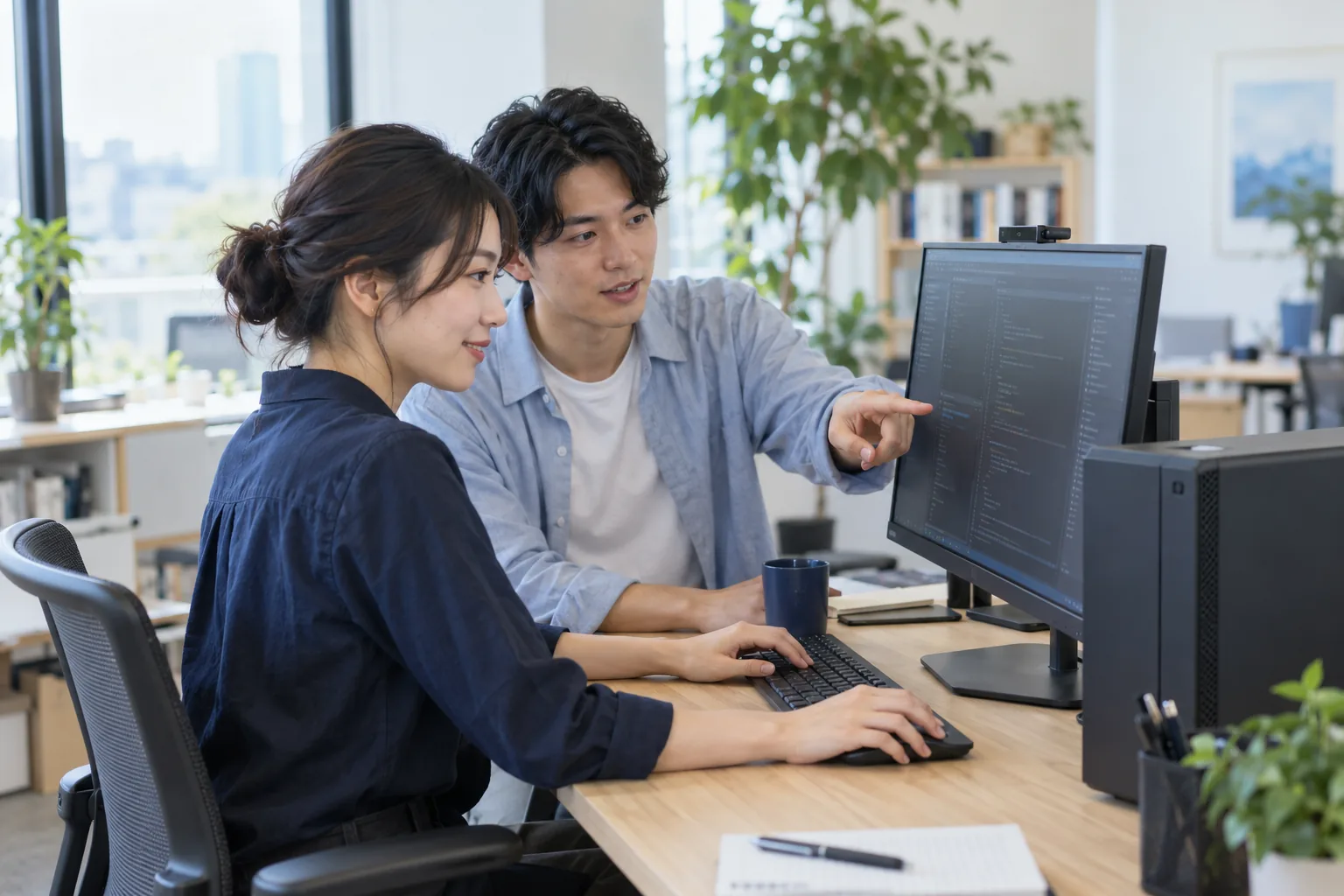 デスクトップPCの画面を見ながら設定を進める若いエンジニアたち